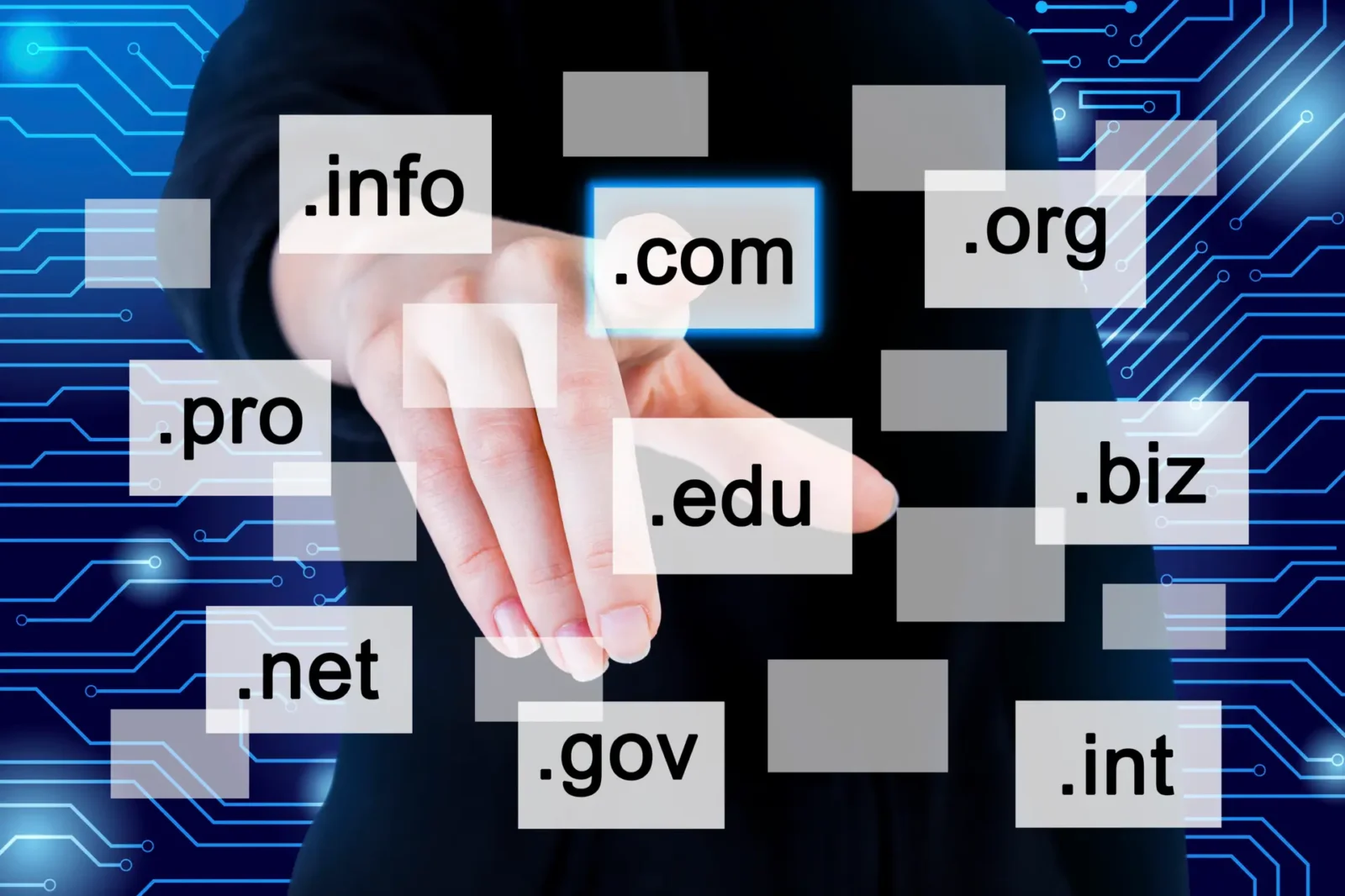 Finger selects a domain tile like .com among other TLDs on a digital circuit background.